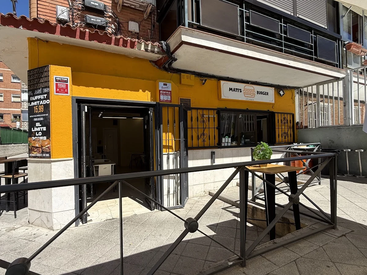 Su fachada mostaza con la terraza y el cartel del buffet